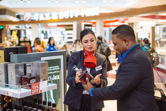 Employee helping customer at a duty free store